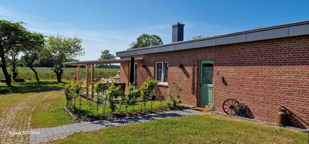 un edificio in mattoni con un giardino di fronte di Ferienwohnung „Klüterkamer“ - Hof Mühlenkoppel a Hasselberg
