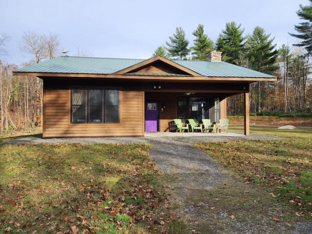 una casa con techo verde y entrada en An Adirondack Getaway, en Keeseville