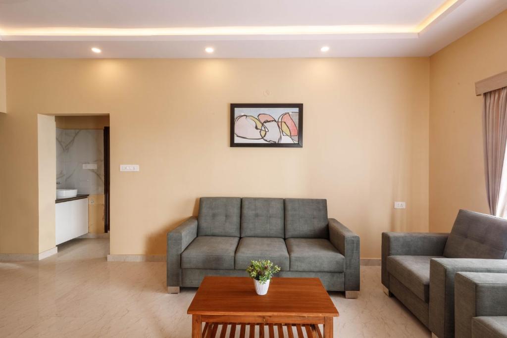 a living room with a couch and a table at Elite Peak Serviced Apartments in Bangalore