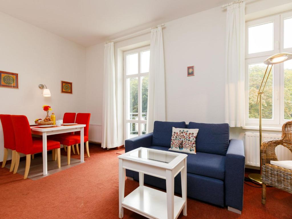 un soggiorno con divano blu e tavolo di Apartment Zinnowitzer Hof-3 by Interhome a Zinnowitz