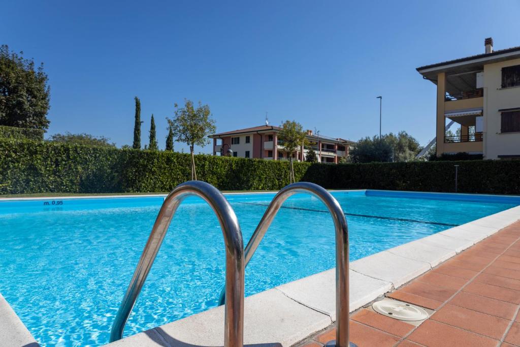 - une piscine avec deux rails métalliques à côté d'un bâtiment dans l'établissement ERNY9, à Sirmione