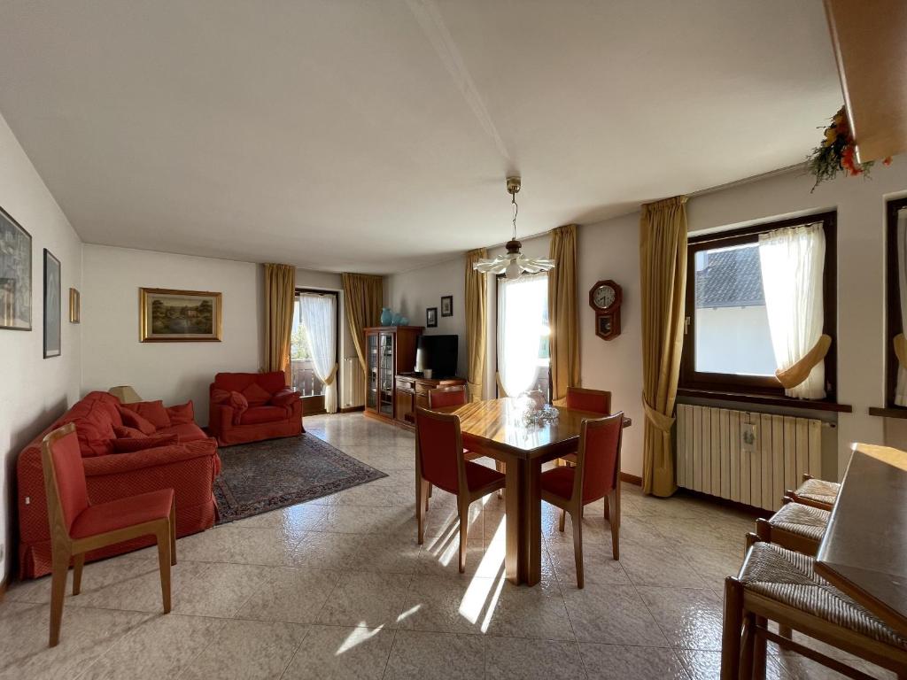 ein Wohnzimmer mit einem Tisch und einem roten Sofa in der Unterkunft 008 Quadrilocale, Pinzolo in Pinzolo
