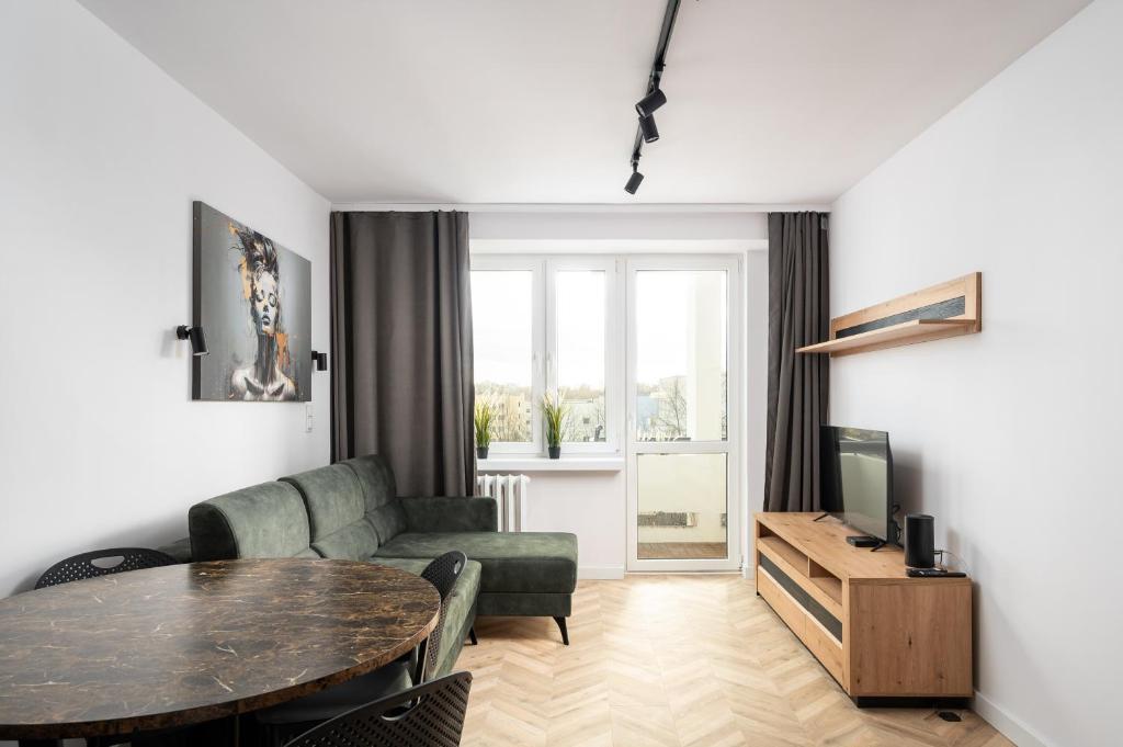 een woonkamer met een bank en een tafel bij Służew 405B Apartment by BookingHost in Warschau