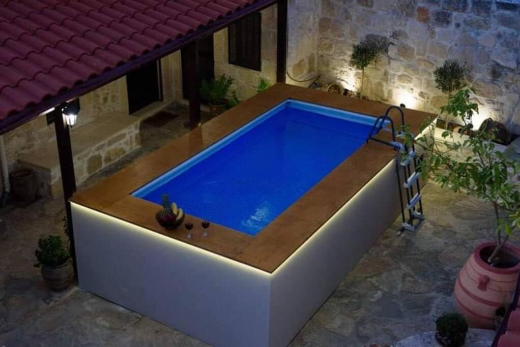 a large swimming pool in a courtyard with a house at Pyrgou Villa Spacious and Unique 1 in Pirgoú