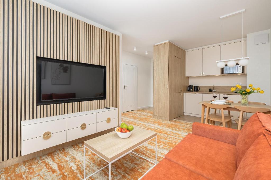 uma sala de estar com um sofá e uma televisão em Rent like home- Elegant Apartments with Balcony em Międzyzdroje