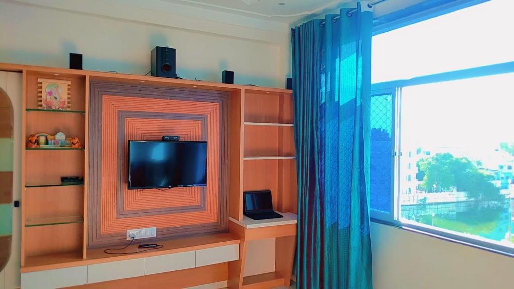 sala de estar con TV y ventana en Antariksh, en Udaipur
