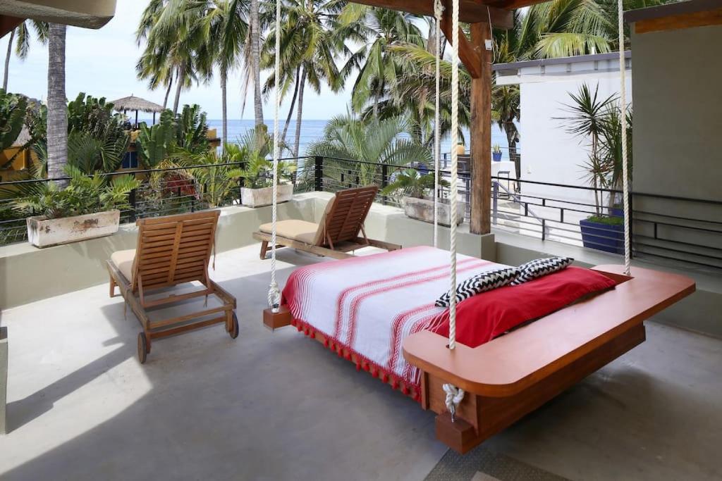 a bedroom with a swinging bed and two chairs at Entire Tocayo Steps to Beach and Surf 4BD Condo with Master Suite in Sayulita