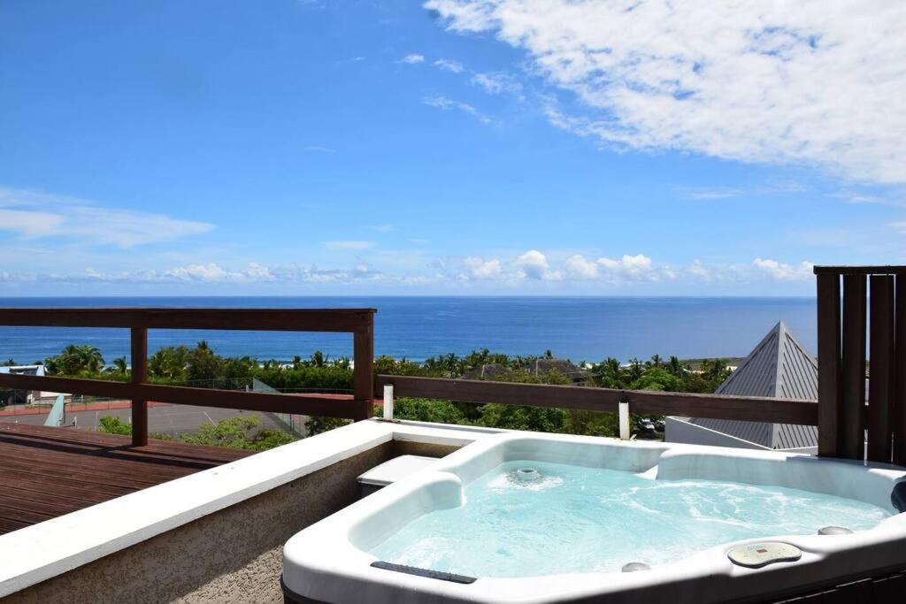 d'un bain à remous sur un balcon avec vue sur l'océan. dans l'établissement Duplex Ti Rooftop spa et vue mer, à Saint-Leu