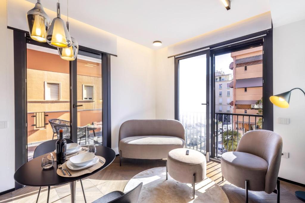 a living room with a table and chairs and a balcony at Vittoria's Luxury Apartment Cagliari in Cagliari