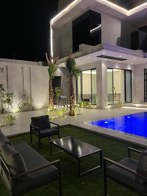 a house with a swimming pool at night at رست فيلا restvilla in Buraydah
