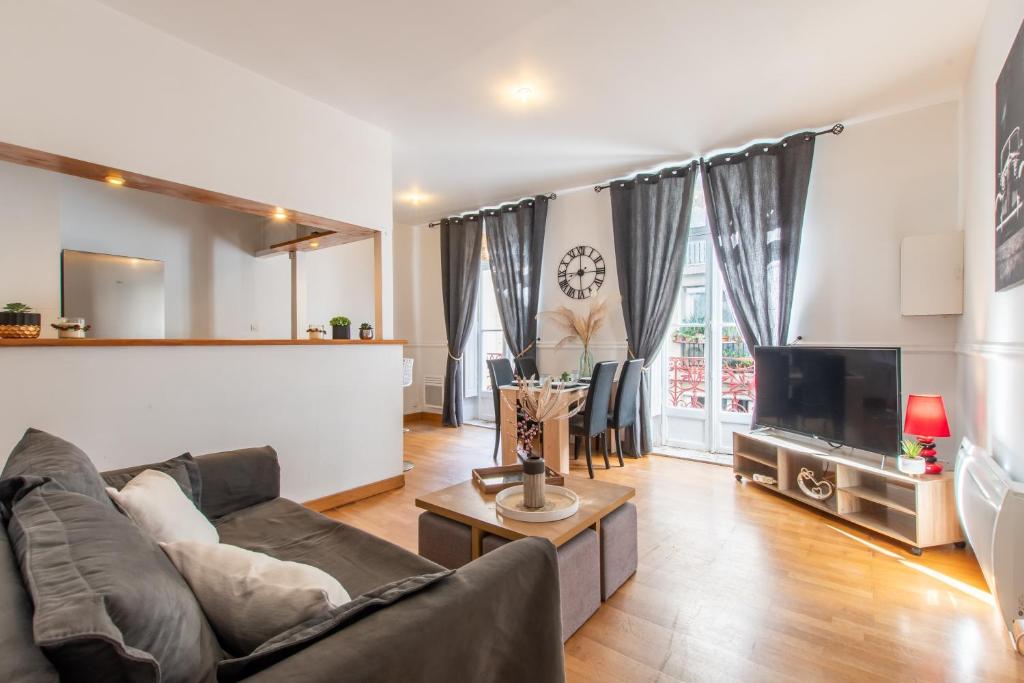 un salon avec un canapé et une télévision dans l'établissement La Comédie de Montpellier - Appt chaleureux, à Montpellier