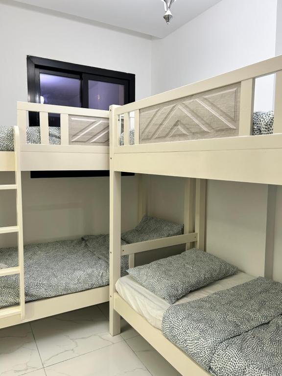 two bunk beds in a room with a window at Homecation in Dubai