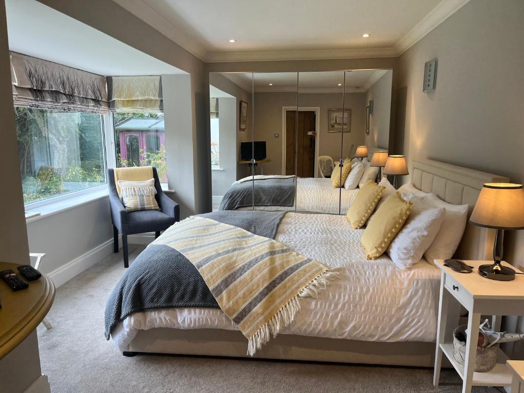 a bedroom with a large bed and a mirror at The Garden Suite in Harrogate