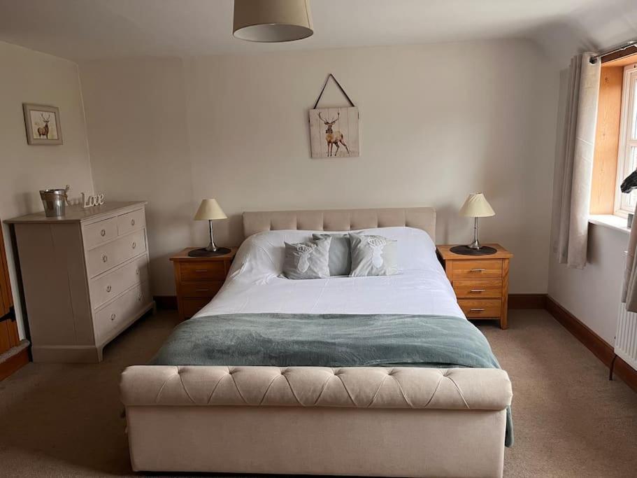 a bedroom with a large white bed with two night stands at The Paddocks in Moulton Chapel