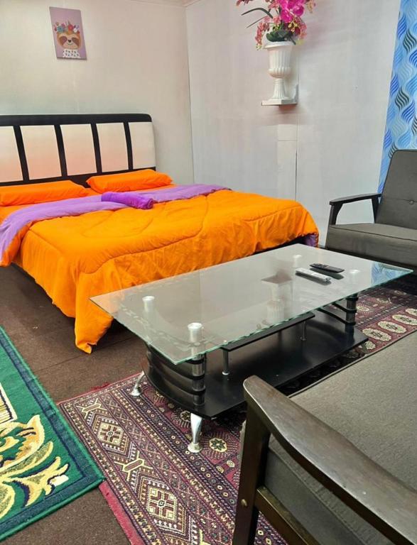 a bedroom with a bed with a glass table and a couch at MAK Room in Kundasang