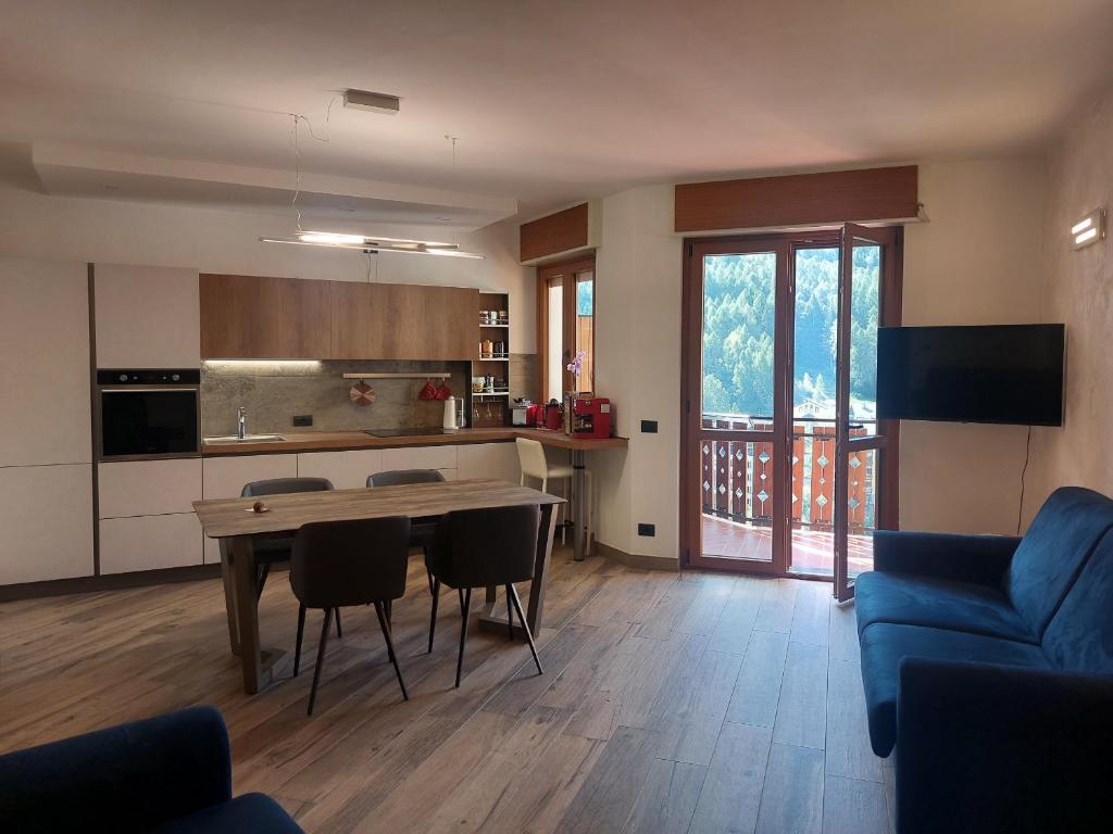 cocina y sala de estar con mesa y sillas en MGH Family Apartment Aprica - Gran Paradis en Aprica