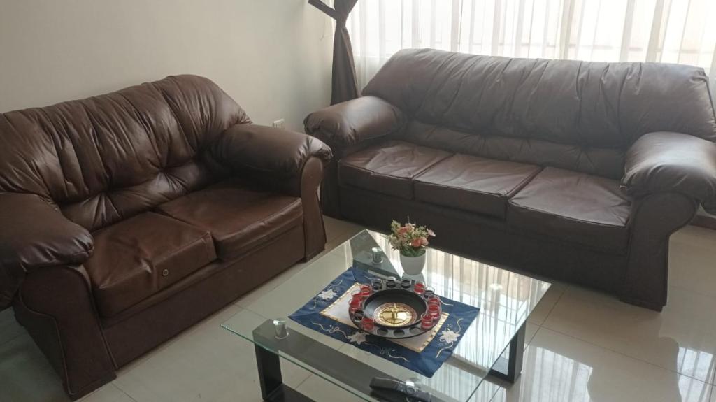 een woonkamer met een bruine bank en een tafel bij Angélica in Miraflores