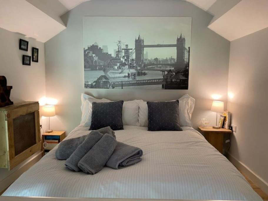 um quarto com uma cama com uma fotografia na parede em ‘The Den’ Self contained one bedroom annexe. em Stockbridge