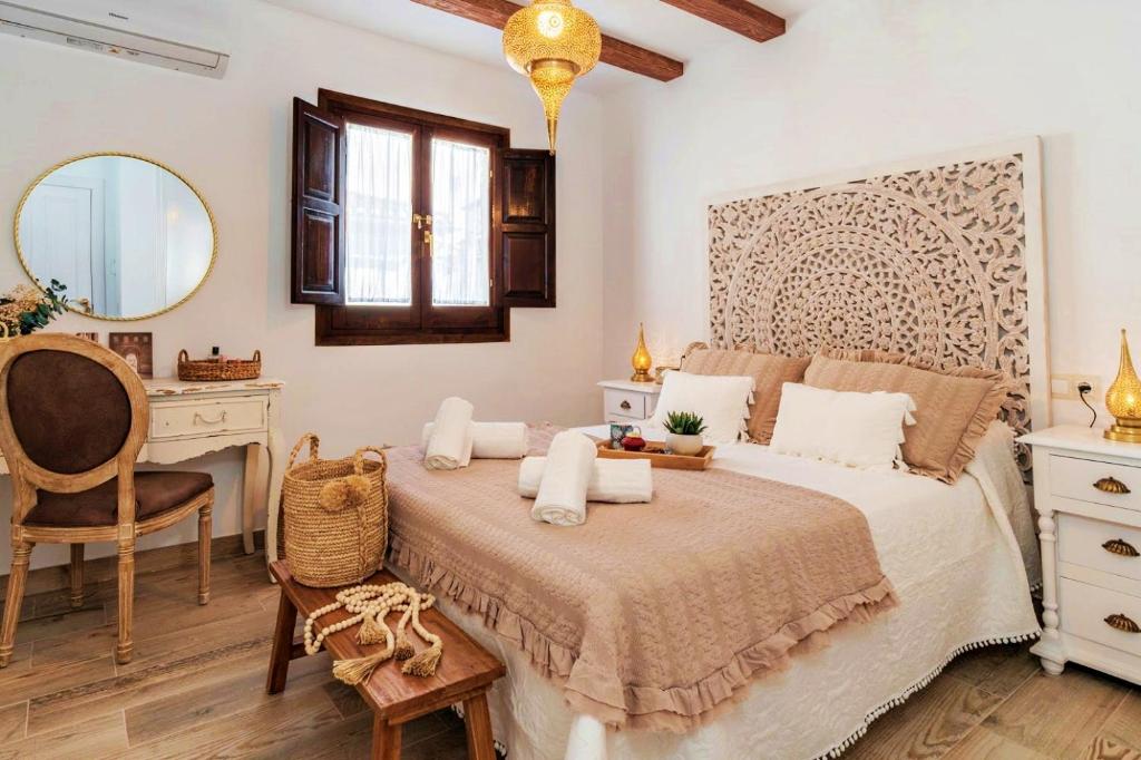 um quarto com uma cama, uma secretária e um espelho em tuGuest Nazarí Calderería Apartments em Granada