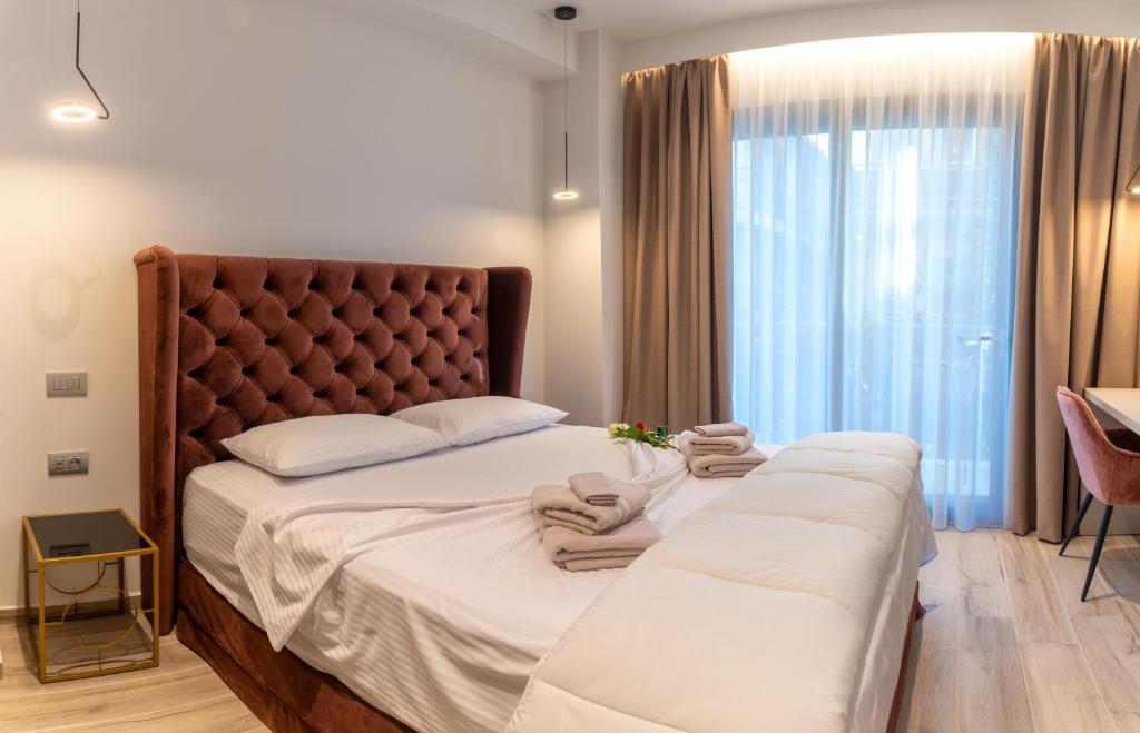 a bedroom with a large bed with a large window at Nicolas Centrale-Smart City Suites in Igoumenitsa