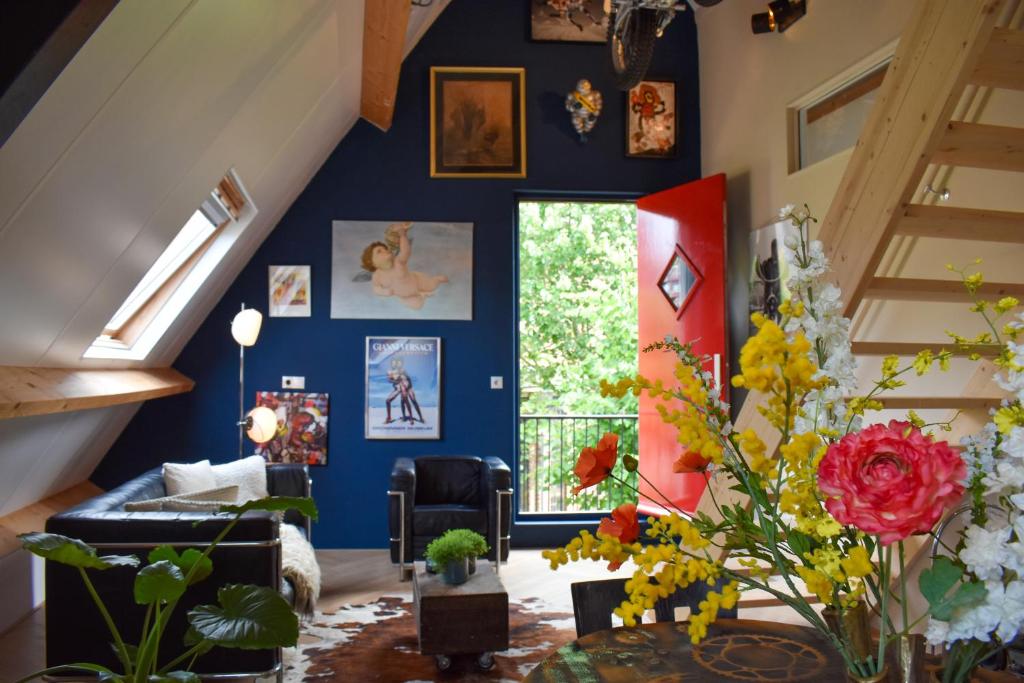 een woonkamer met een blauwe muur met schilderijen bij Stijlvol appartement 'Moto' in centrum Franeker. in Franeker