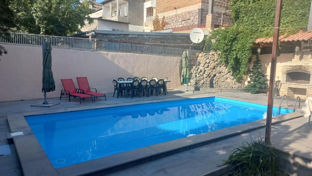 a swimming pool with two chairs and a table and chairs at TownHouse with pool in Yerevan