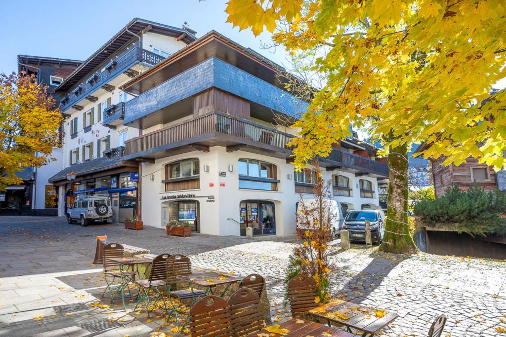 a building with a table and chairs in front of it at Résidence Les Arcades du Mont-Blanc in Megève