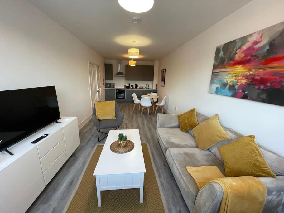 a living room with a couch and a tv at Beautiful Flat In Woking Central in Woking