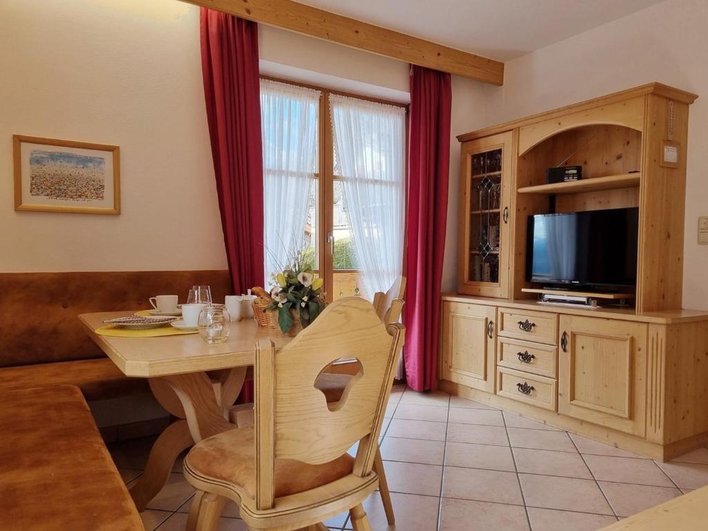 sala de estar con mesa de madera y TV en Julia -702-, en Mittenwald