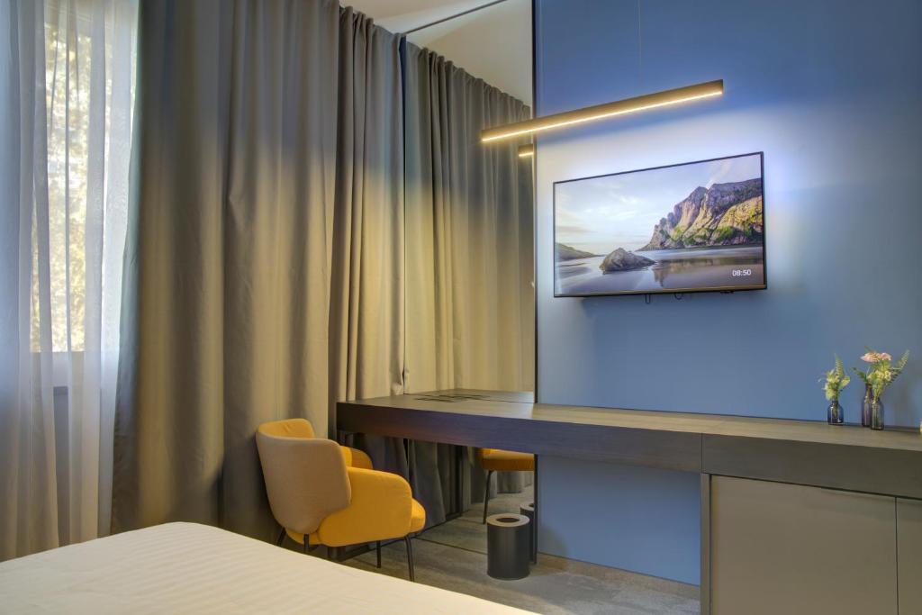 um quarto de hotel com uma televisão na parede em Avenue21 em Zagreb