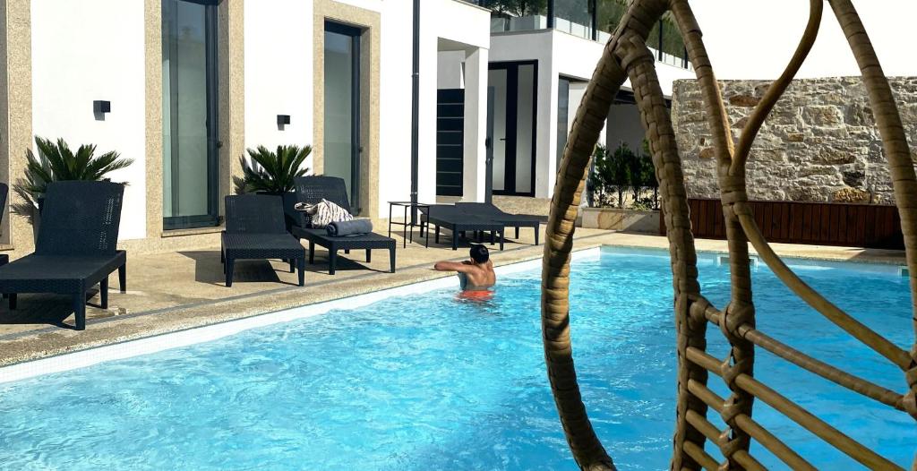 un homme dans la piscine d'un hôtel dans l'établissement BLUE ANCORA HOTEL, à Vila Praia de Âncora