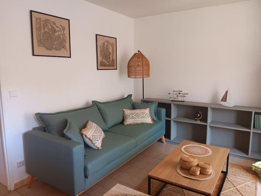 un salon avec un canapé bleu et une table dans l'établissement WEEK END A LA MER, à Fréjus