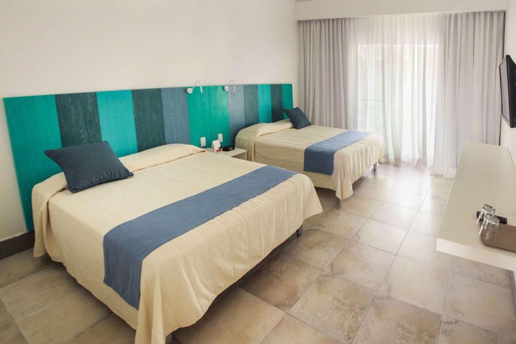 Postel nebo postele na pokoji v ubytování Viva Tangerine by Wyndham, A Trademark All Inclusive