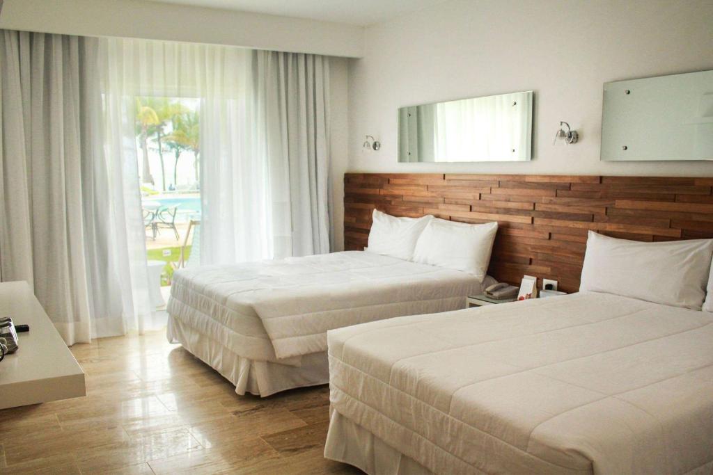 Postel nebo postele na pokoji v ubytování Viva Tangerine by Wyndham, A Trademark All Inclusive