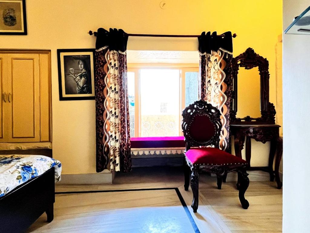 um quarto com uma cadeira e uma janela em Hotel Himmat Niwas em Jaisalmer