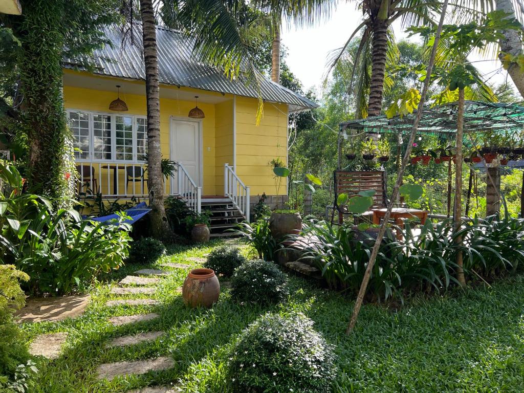 a yellow house with a porch and a yard at Tropical Garden Phu Quoc in Phú Quốc