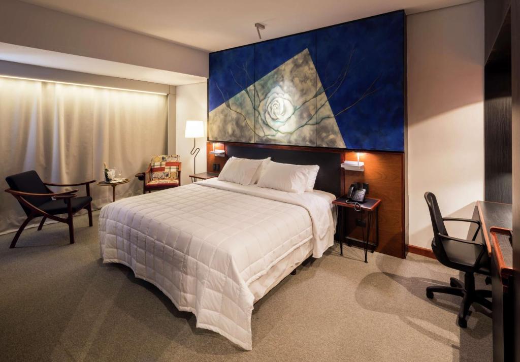 1 dormitorio con 1 cama grande y una gran pintura en la pared en Hilton Garden Inn Asuncion Aviadores Del Chaco en Asunción