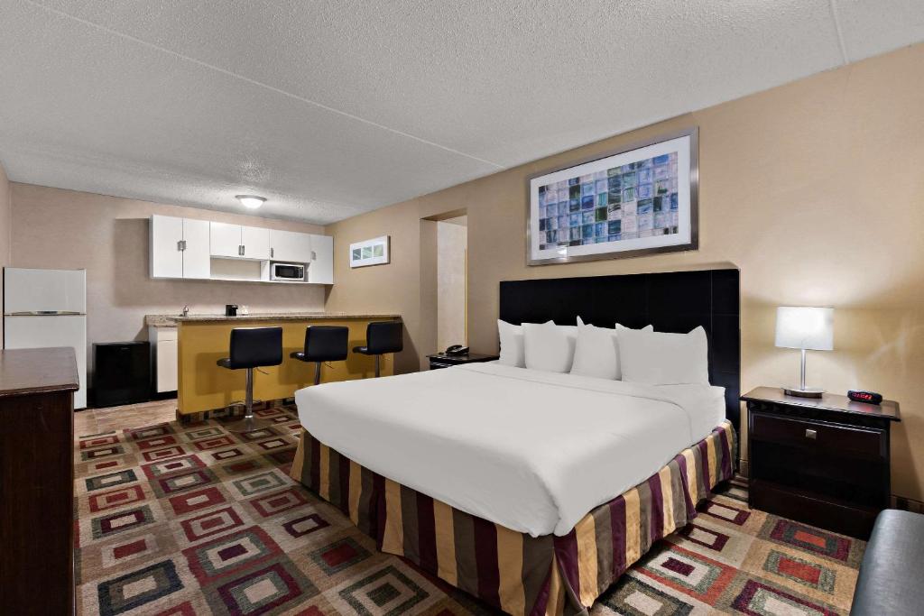 a hotel room with a large bed and a kitchen at Quality Inn Wayne - Fairfield Area in Wayne