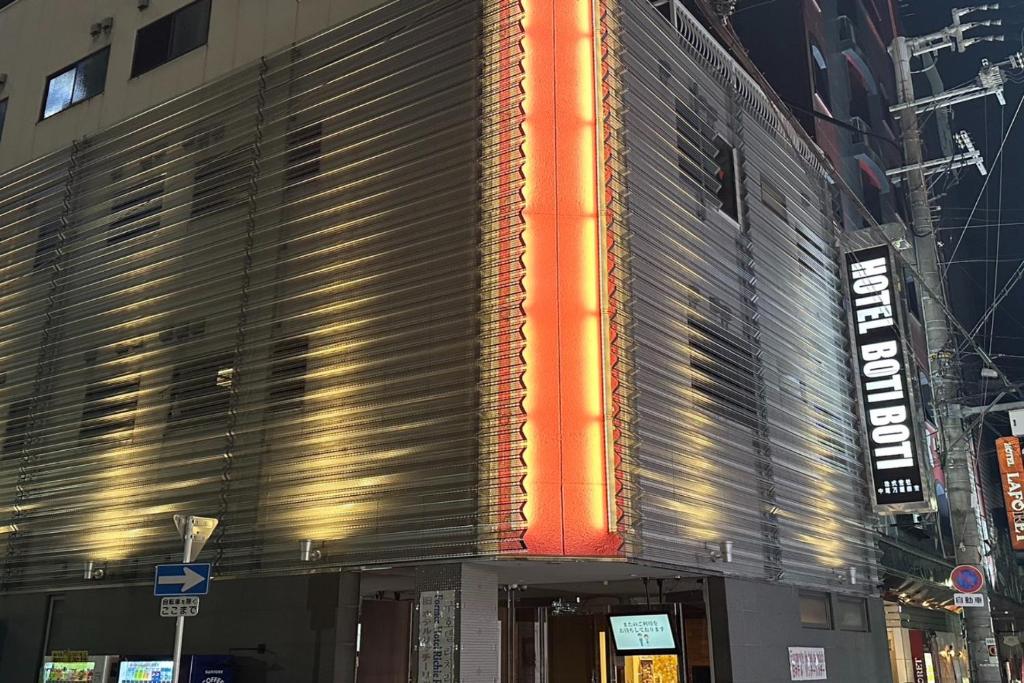 a building is lit up with orange lights on it at Hotel Boti Boti in Osaka