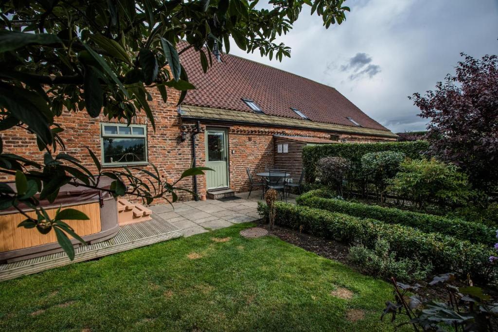 a brick house with a green door and a yard at The Forge in Selby