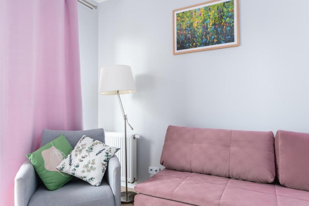 a living room with a purple couch and a lamp at Jesionowa Standard Apartment in Wrocław