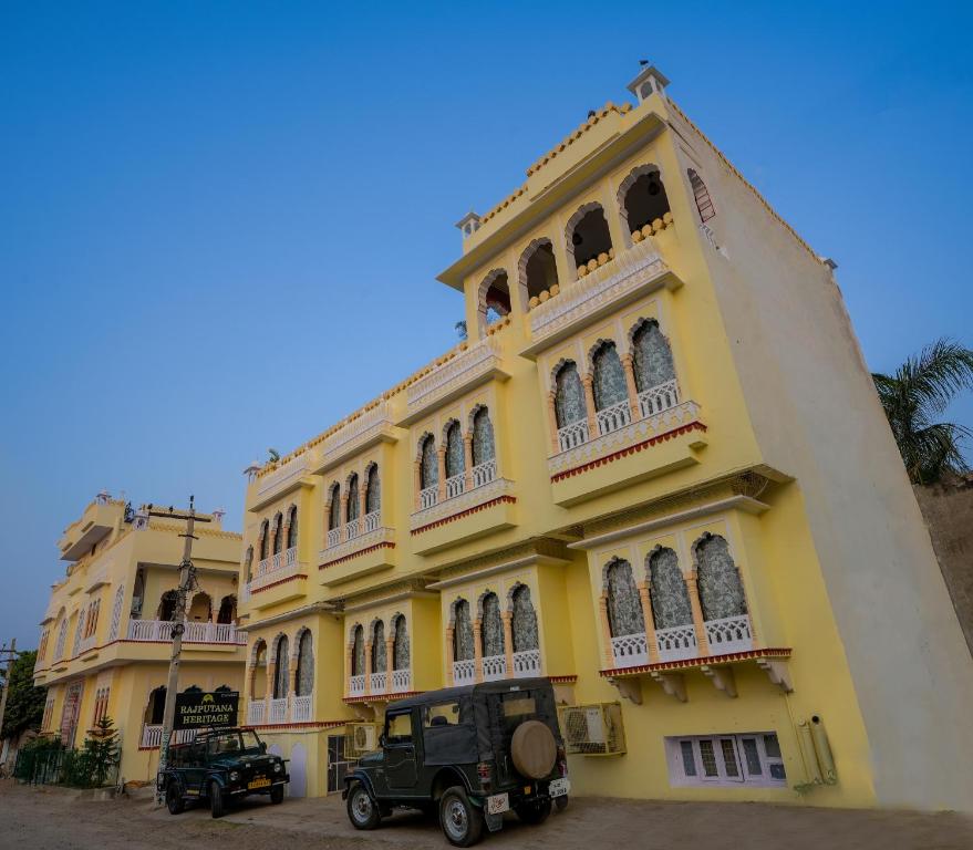 ein gelbes Gebäude mit einem LKW, der davor parkt. in der Unterkunft Rajputana Heritage in Sawāi Mādhopur