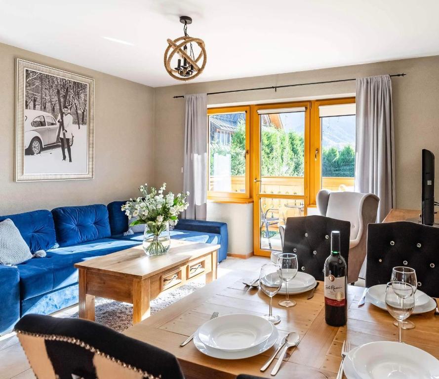 a living room with a blue couch and a table at Villa Delta Boutique in Kościelisko