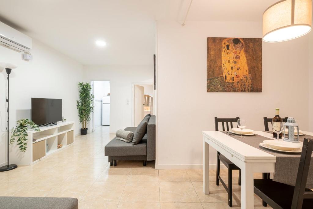 a dining room and living room with a table and chairs at Apartment next to Europa Fira and 20' from Barcelona city center in Hospitalet de Llobregat