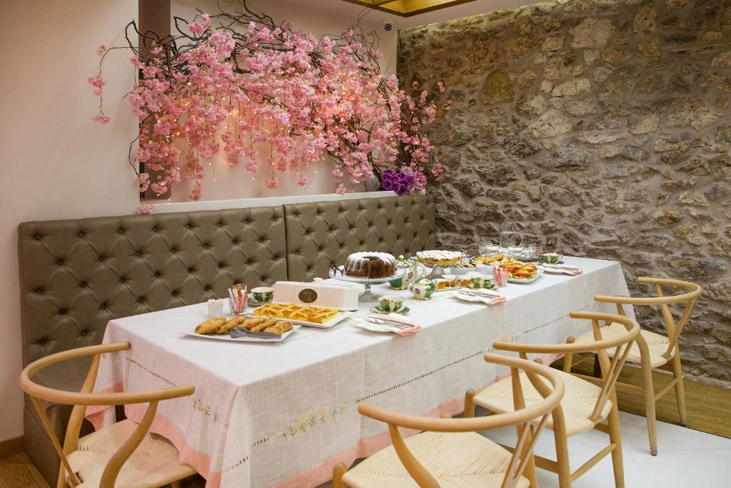 una mesa con comida y flores en una pared en Sweet Home Hotel, en Atenas