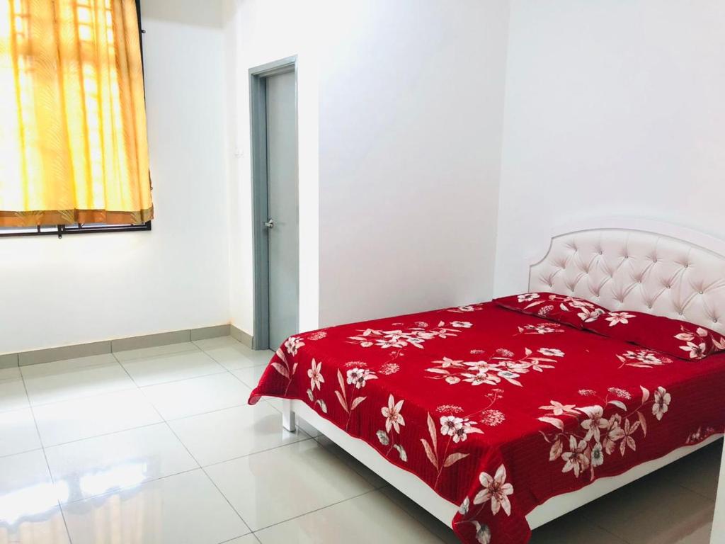 a red bed in a white room with a red blanket at D' HOME MERIDIAN in Kluang