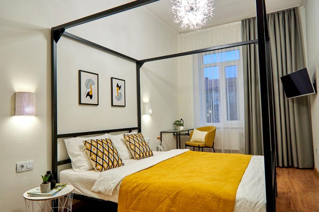a bedroom with a large bed with a yellow blanket at Best Apartments on Kyryla & Mefodia in Mukacheve