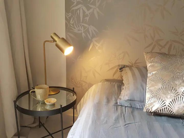 a table with a lamp next to a bed at The Superstay Boutique guestroom in Amsterdam