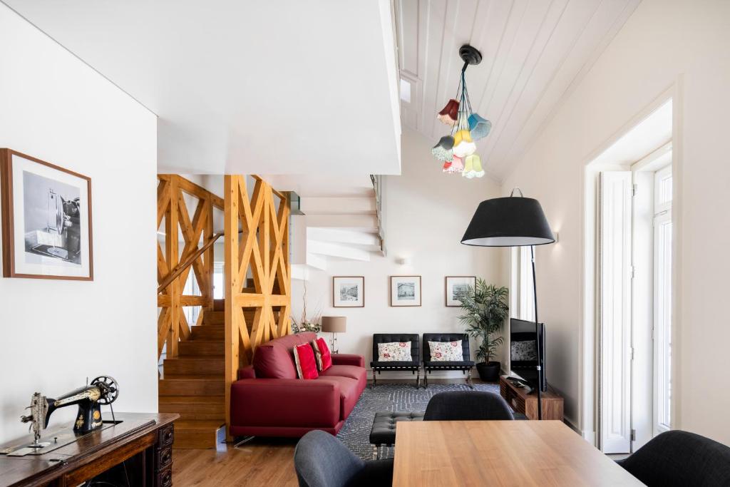 a living room with a red couch and a table at Chiado Trindade Apartments | Lisbon Best Apartments in Lisbon