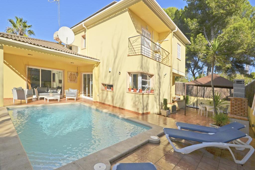 a swimming pool in front of a house at Villa Prestige in Can Picafort